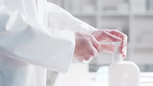 Close-up of doctor cleaning hands using disinfectant with medical soap.