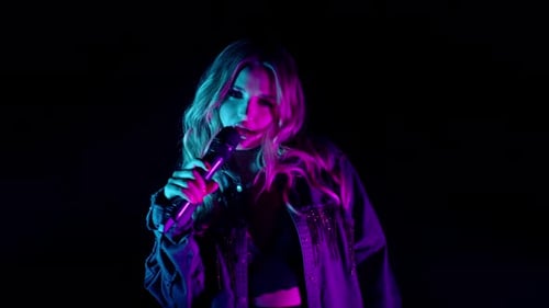 Young Woman Singing with Microphone in Neon Lights