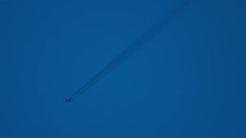 Jet Airplane Flying Leaving Contrail in Blue Sky
