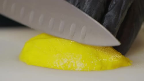 Slicing a Yellow Mango with a Knife
