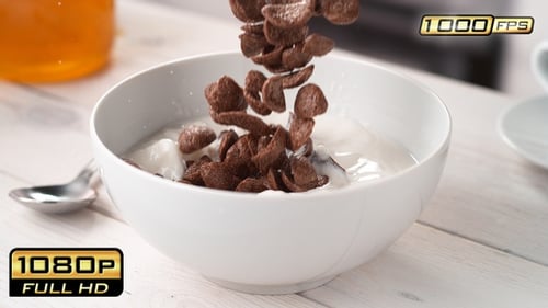 Chocolate Cereal Flakes Falling into Bowl of Milk