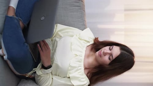 Woman Using Laptop Computer While Sitting on Couch