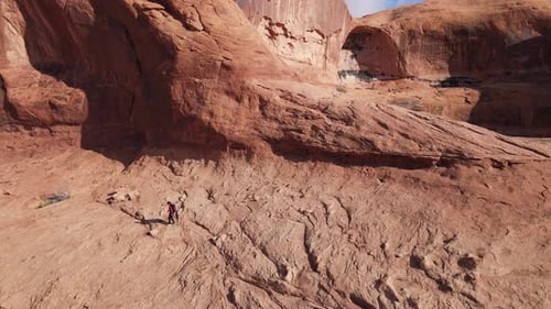 Desert Landscape with Red Rocks and Solitary Hiker