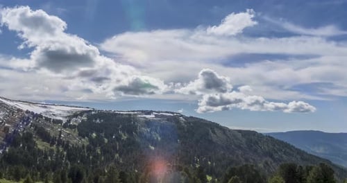 Time Lapse of Cloudscape Behind of the Mountains Top. Snow, Rocks, Cliffs and Deep Blue Sky