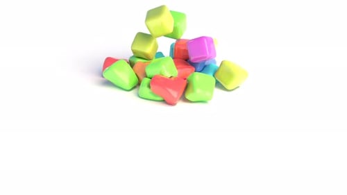 Los cubos de goma de colores caen sobre una superficie blanca