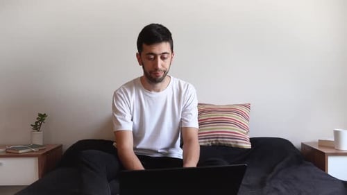 Focused Man Works On Laptop at Home
