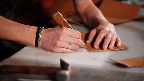 Close Up Shot of a Man's Hands, Who Makes a Note with a Knife on Leather Details