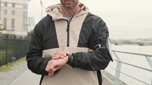 Man Checks Watch on Urban Walkway