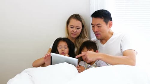 Family Using Tablet Together in Bed