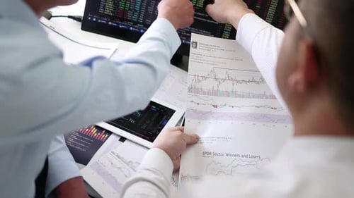 Two Men Looking at Stock Data at Desk
