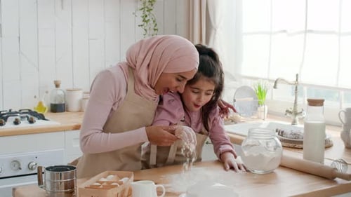 Arabic Mother And Daughter Using Flour Making Dough In Kitchen
