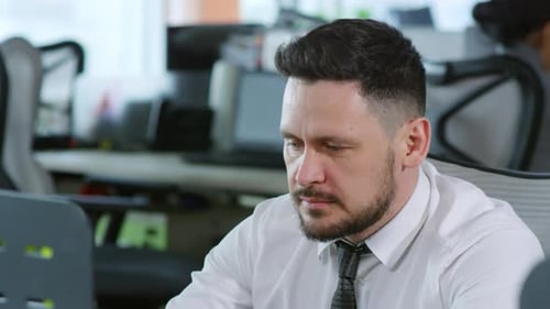 Fröhlicher Mann sitzt am Schreibtisch