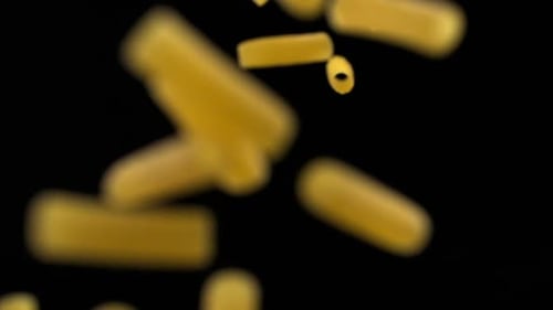Uncooked Pasta Falling on Black Background