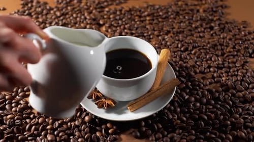 Primer plano de verter leche en una taza de café negro