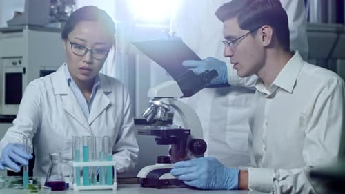 Chemists Analyzing Liquids from Test Tubes