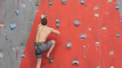 Shirtless Man Indoor Rock Climbing at Gym