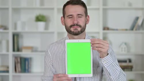 Man Holding Tablet with Green Screen Display