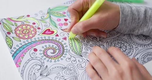 Person Coloring Intricate Designs With Bright Markers