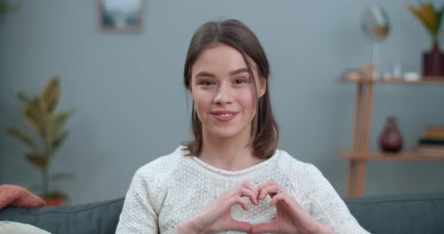Crop View of Millennial Woman Saying Nonverbal Phrase I Hear It with My Heart While Sitting on Couch