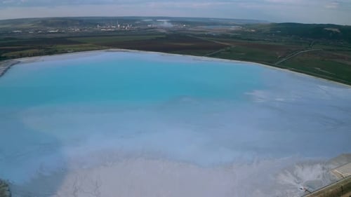 Aerial view of a reservoir full of blue toxic sludge