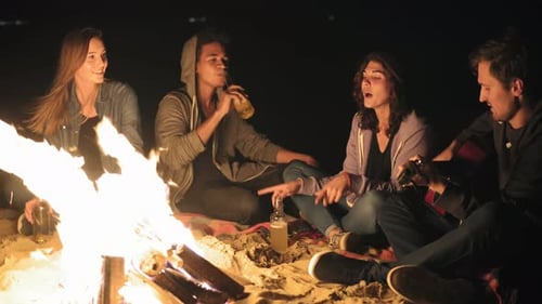 Friends Enjoying Bonfire Music on a Beach at Night