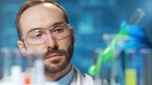 Focused Scientist Examining Test Tubes in Laboratory