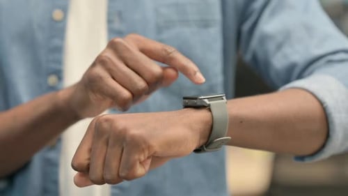 Hände eines afrikanischen Mannes mit Smartwatch