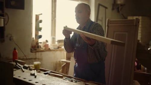 Woodworker Inspecting a Wooden Plank in Workshop
