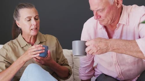 Mature Couple Relaxing Together on Couch with Coffee