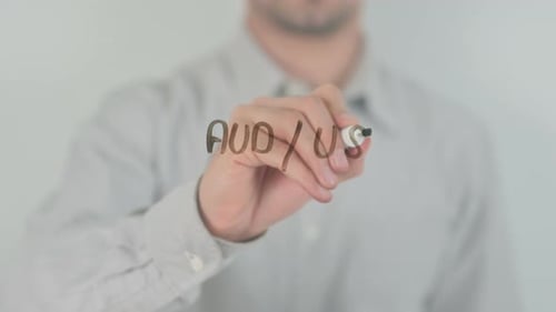 AUDUSD Australischer Dollar gegen Dollar, der mit der Hand auf dem Bildschirm geschrieben wird