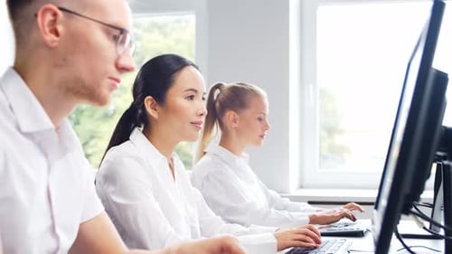 Diverse team of young professionals is working in the phone support office.