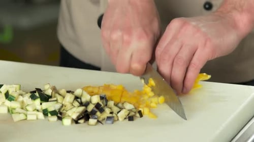 Hands Dicing Yellow Pepper on Cutting Board