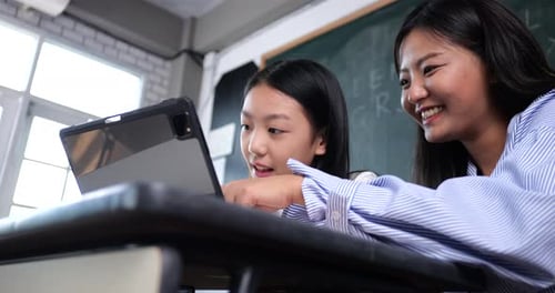 Student and Teacher Working Together on Tablet at School