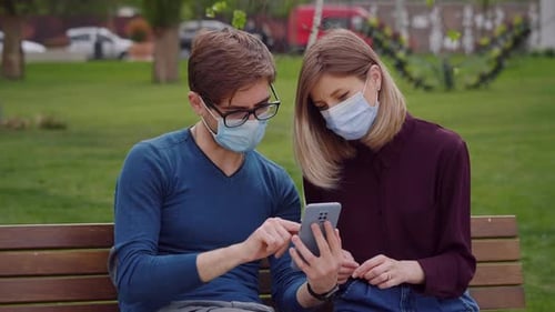 Two cute people look closely on phone and find out from news End of covid-19