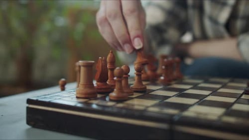The Girl Puts the Pieces on the Chessboard Close Up