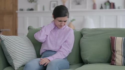 Young Woman Experiencing Neck Pain on Couch