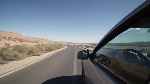 Driving on Empty Road Through Dry Barren Landscape