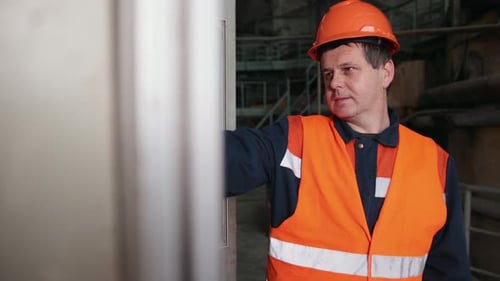 Factory Worker Opens Equipment Control Panel