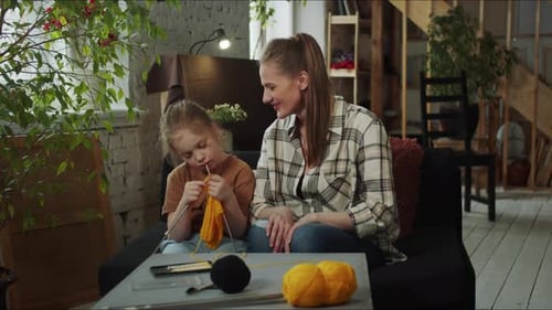 Mother and Child Knitting Together at Home