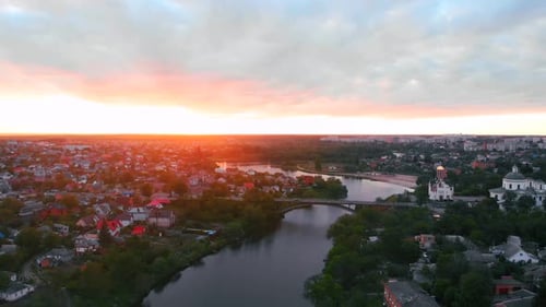 Zumbido vuela sobre el río en una hermosa ciudad europea durante la puesta de sol en primavera