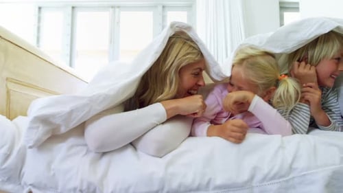 Family Playing Together Underneath a White Blanket