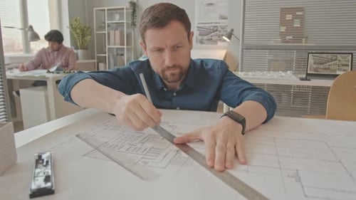 Architect Drawing House Plan at Office Desk