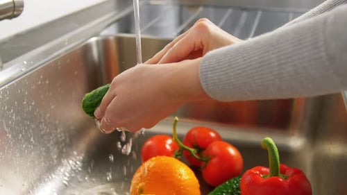 Woman Washing Fruits and Vegetables in Kitchen