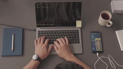 Manos del programador escribiendo código de programa en la computadora portátil