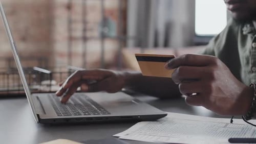 Typing on Laptop and Holding Credit Card