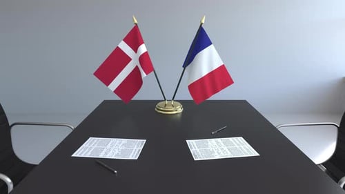 Denmark and France Flags on Conference Table for Business Agreement