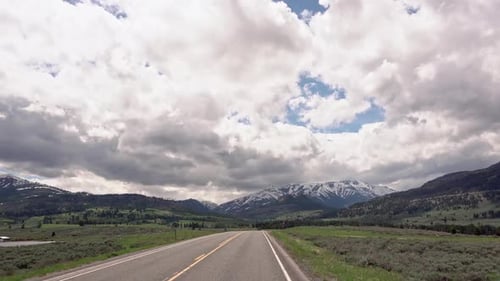Driving on road through mountain valley landscape