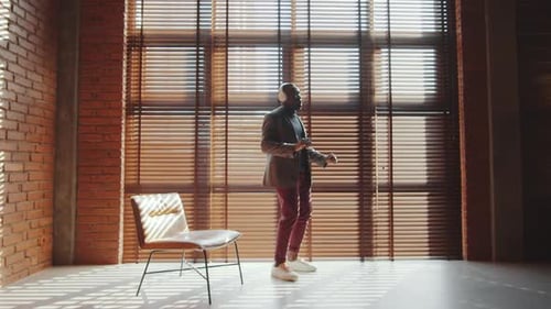 Afro-American Man in Headphones Dancing in Home Office