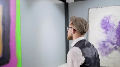 Kunstliebhaber schaut auf ein erstaunliches abstraktes Bild in der sich bewegenden Museumskamera