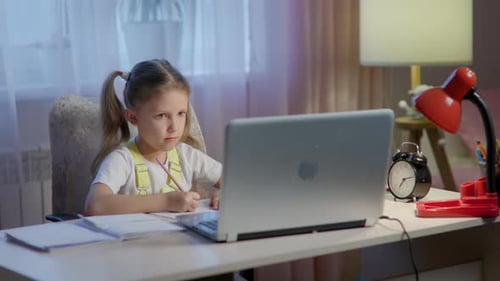 Girl Does Homework at Desk with Laptop